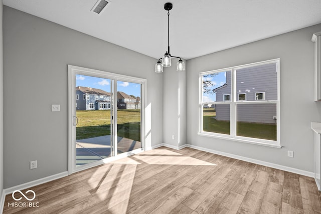 unfurnished dining area featuring light wood-type flooring