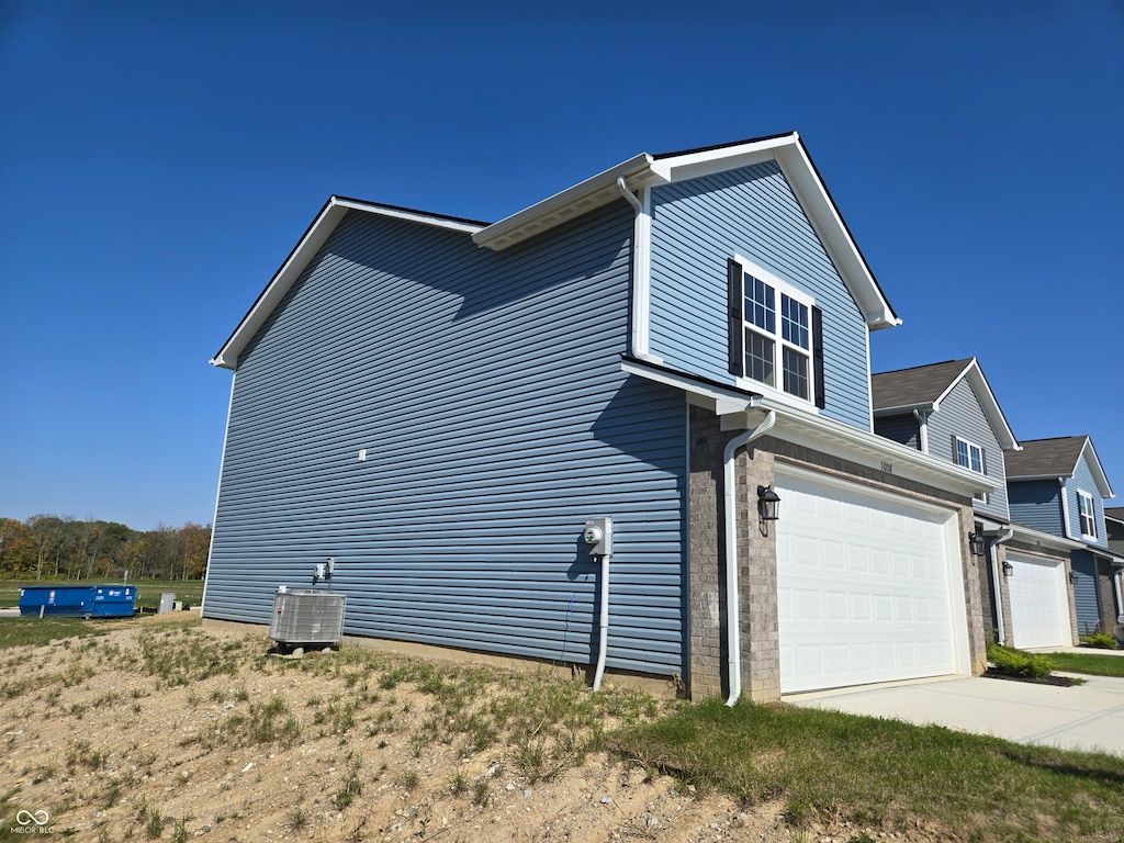 view of property exterior with a garage and cooling unit