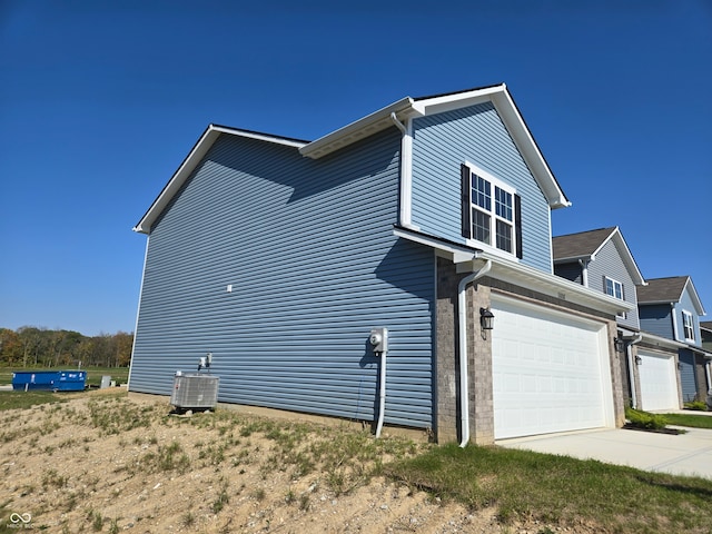 view of property exterior with a garage and cooling unit