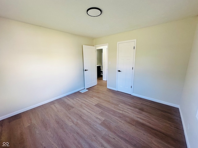 unfurnished bedroom with hardwood / wood-style flooring and a closet