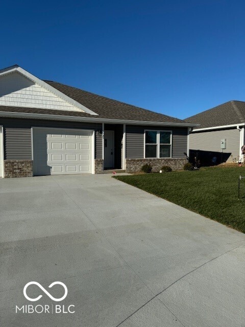 ranch-style home with a front lawn and a garage