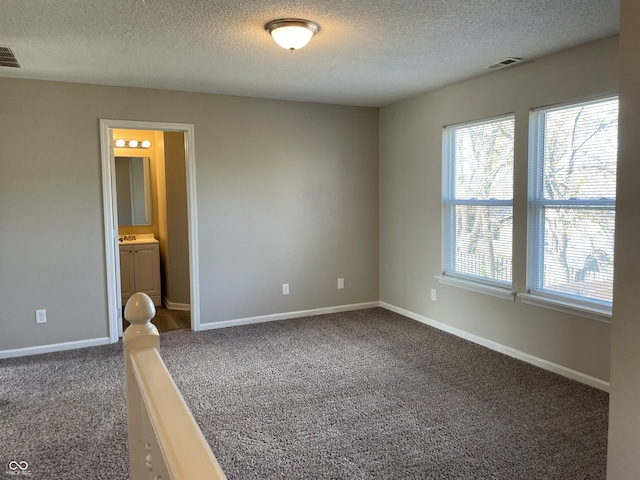 carpeted spare room with a textured ceiling