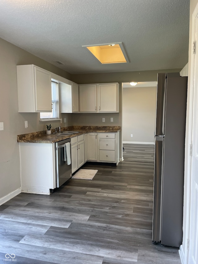 kitchen featuring white cabinets, appliances with stainless steel finishes, and dark hardwood / wood-style floors