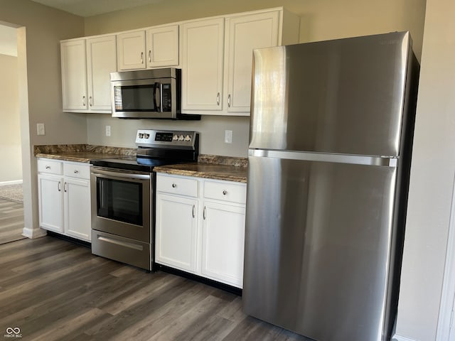 kitchen with dark stone counters, white cabinetry, dark hardwood / wood-style flooring, and stainless steel appliances