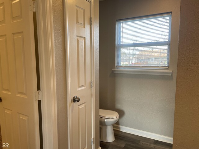 7530 Redcliff Rd, Indianapolis, IN 46256 - bathroom featuring wood finished floors, toilet, baseboards, and a textured wall