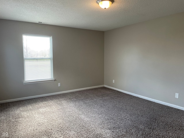 unfurnished room featuring carpet and a textured ceiling