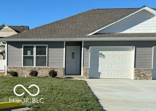 view of front of home with a front yard and a garage