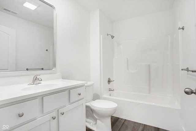 full bathroom with hardwood / wood-style flooring, vanity,  shower combination, and toilet