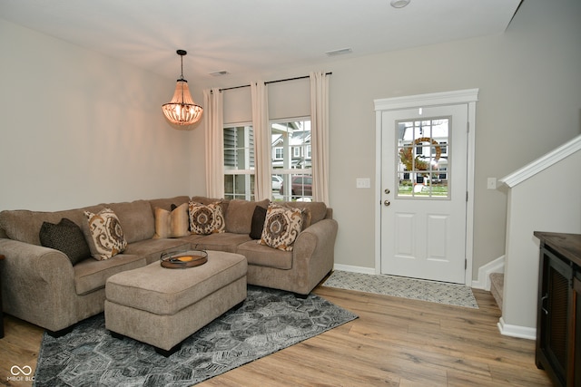 living room with hardwood / wood-style flooring and a notable chandelier