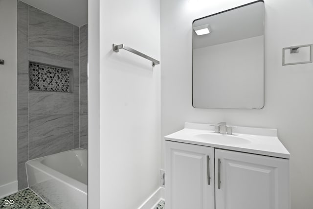 bathroom with tile patterned flooring, vanity, and tiled shower / bath