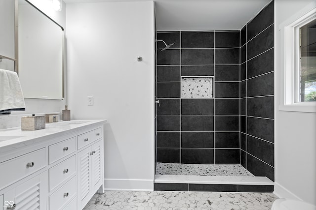 bathroom featuring a tile shower, vanity, and tile patterned floors