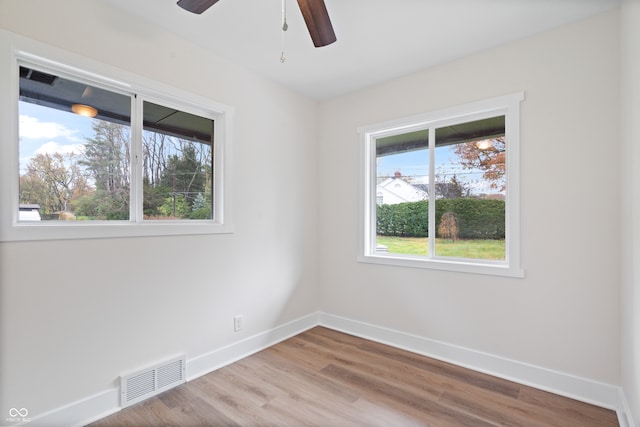 spare room with light hardwood / wood-style flooring, plenty of natural light, and ceiling fan