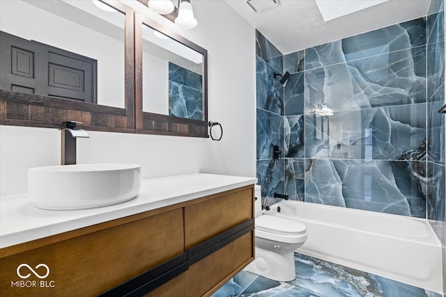 full bathroom with tiled shower / bath combo, toilet, and vanity