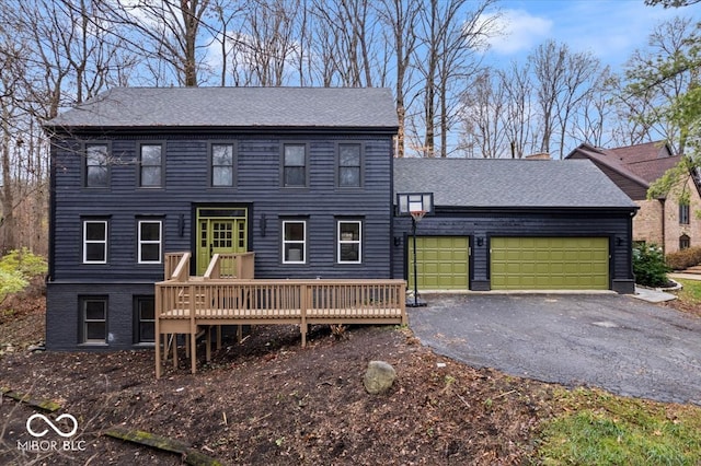 colonial inspired home with a garage and a deck