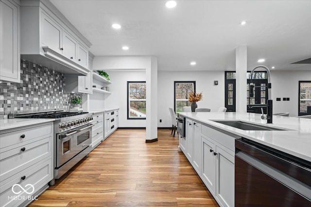 kitchen featuring white cabinets, double oven range, light wood-type flooring, and black dishwasher