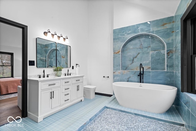 bathroom with tile patterned floors, vanity, a bathing tub, and tile walls