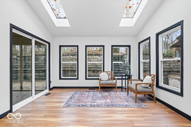 sunroom / solarium featuring vaulted ceiling with skylight