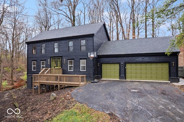 colonial home with a garage and a wooden deck