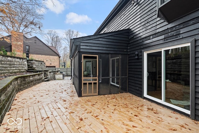 wooden terrace with a sunroom and an outdoor kitchen