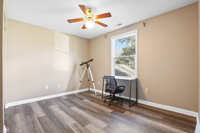 home office with ceiling fan and dark hardwood / wood-style flooring