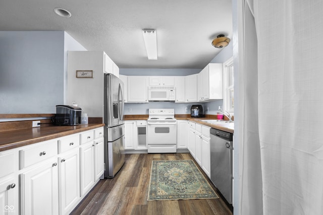 kitchen featuring sink, white cabinets, stainless steel appliances, and dark hardwood / wood-style floors