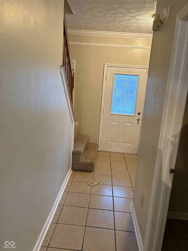 doorway to outside featuring a textured ceiling, crown molding, and light tile patterned flooring