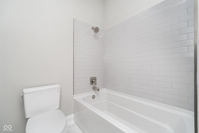 bathroom featuring tiled shower / bath combo and toilet