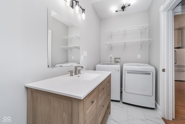 laundry area with separate washer and dryer and sink