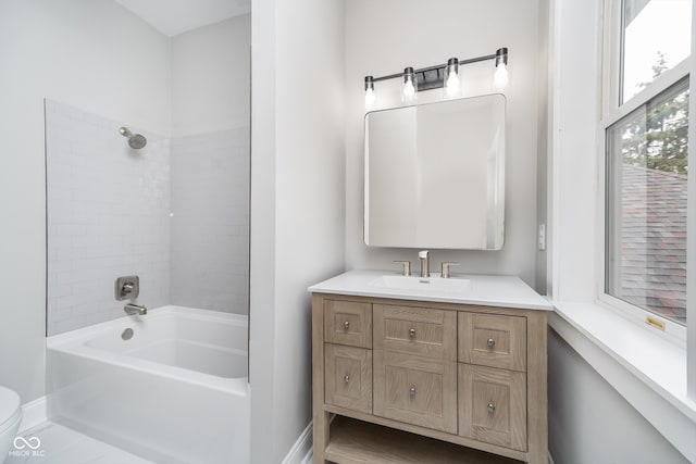 full bathroom featuring vanity, tiled shower / bath combo, and toilet