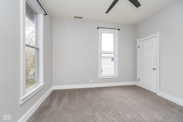 empty room with carpet flooring, plenty of natural light, and ceiling fan