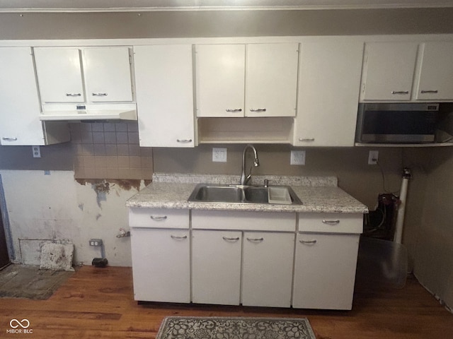 kitchen with backsplash, white cabinetry, sink, and dark hardwood / wood-style floors