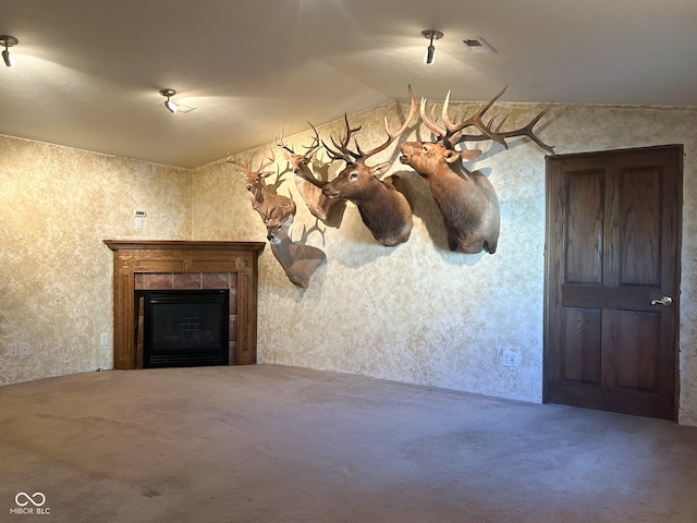 interior space featuring lofted ceiling and a tile fireplace