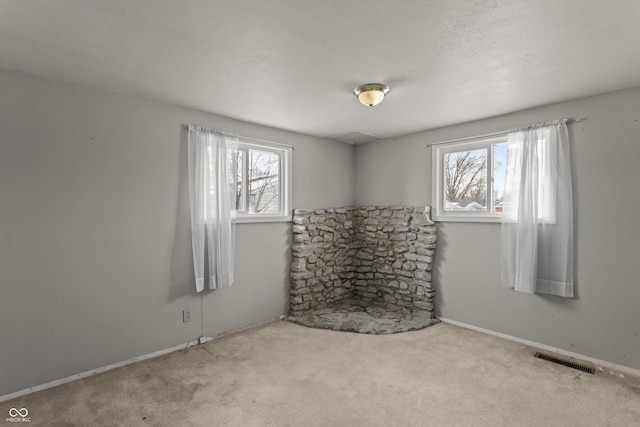 carpeted empty room featuring a textured ceiling