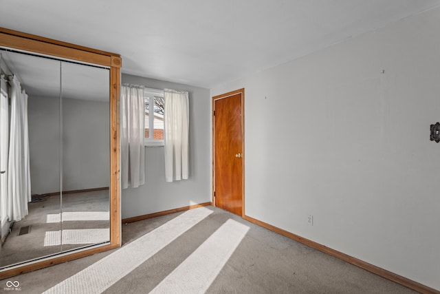 unfurnished bedroom with a closet and light colored carpet