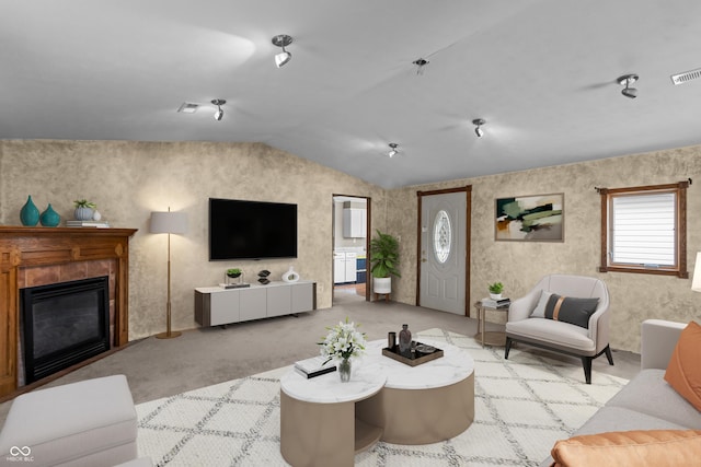 living room featuring a fireplace, light carpet, and lofted ceiling