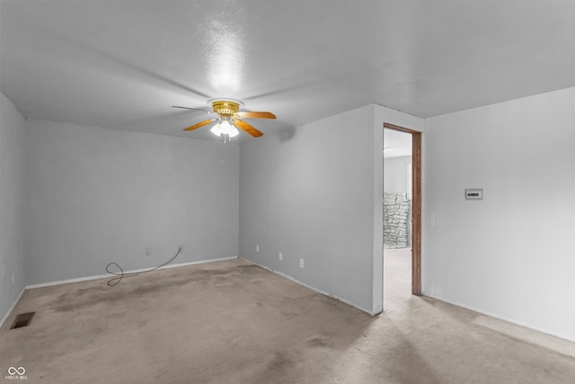 spare room featuring light carpet and ceiling fan