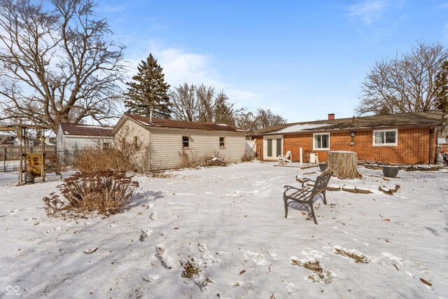 snow covered house featuring a storage shed