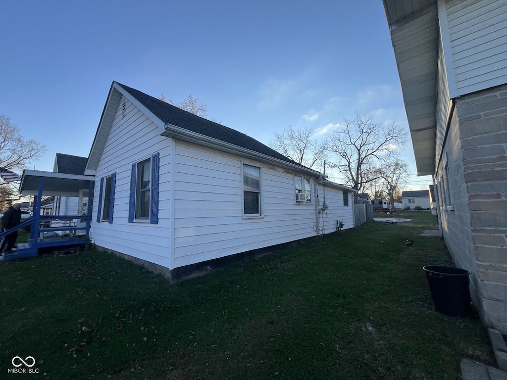 view of side of property with a yard and cooling unit