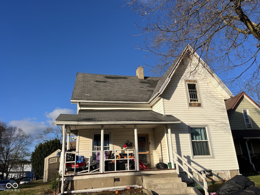 view of front of house with covered porch and a shed