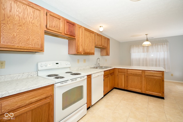 kitchen with decorative light fixtures, white appliances, sink, and kitchen peninsula