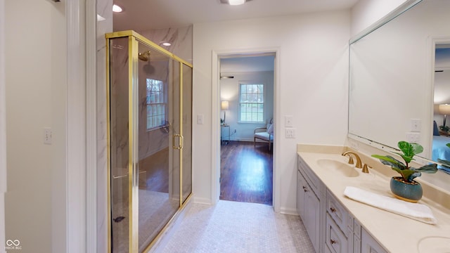 bathroom with hardwood / wood-style floors, vanity, and a shower with shower door