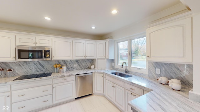 kitchen with tasteful backsplash, white cabinetry, sink, and appliances with stainless steel finishes