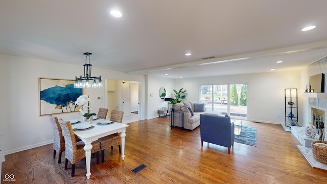 dining area with light wood-type flooring and a chandelier