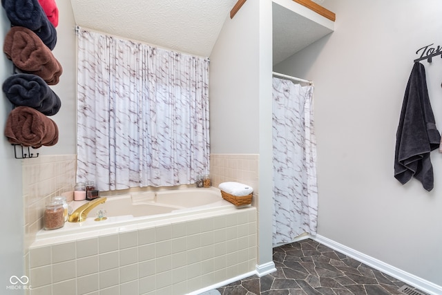 bathroom featuring tiled tub and a textured ceiling