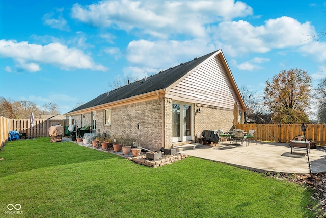 rear view of property featuring a yard and a patio