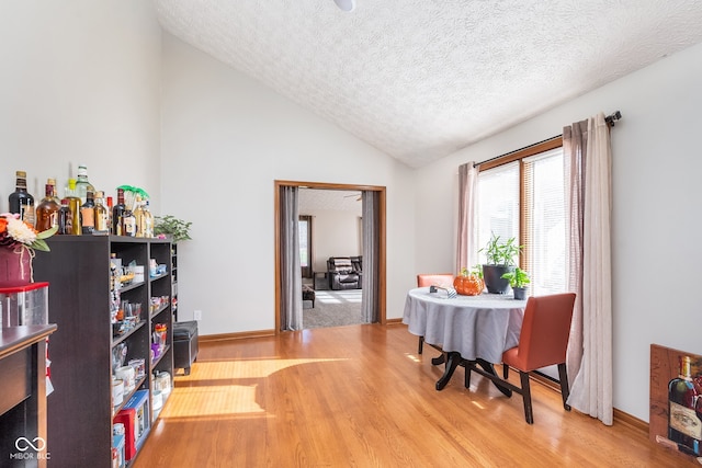 home office with vaulted ceiling, hardwood / wood-style floors, and a textured ceiling