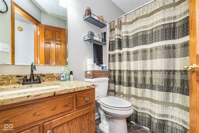 bathroom featuring vanity, a textured ceiling, and toilet