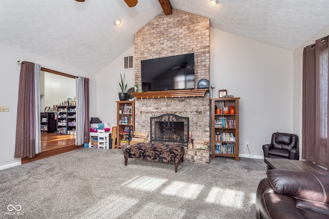 carpeted living room with a fireplace, a textured ceiling, lofted ceiling with beams, and ceiling fan