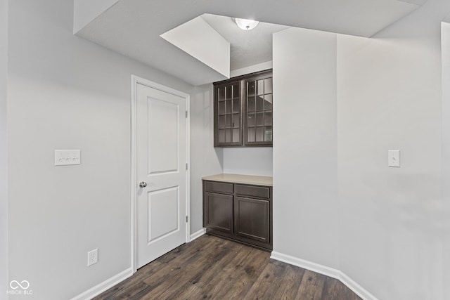 interior space with dark brown cabinets and dark wood-type flooring