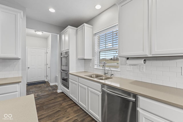 kitchen featuring white cabinets, appliances with stainless steel finishes, dark hardwood / wood-style flooring, and sink